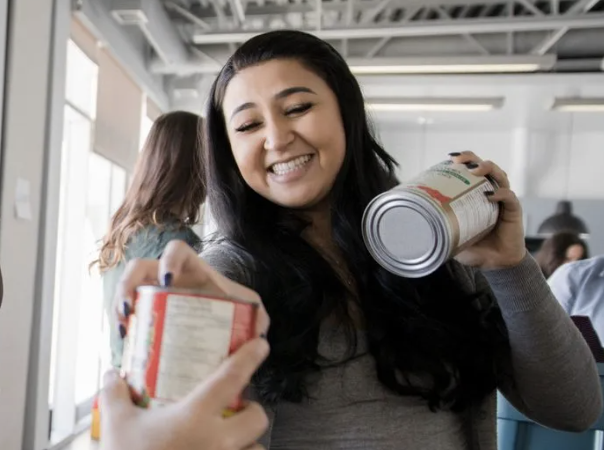 Charity worker giving cans of food to a person in need